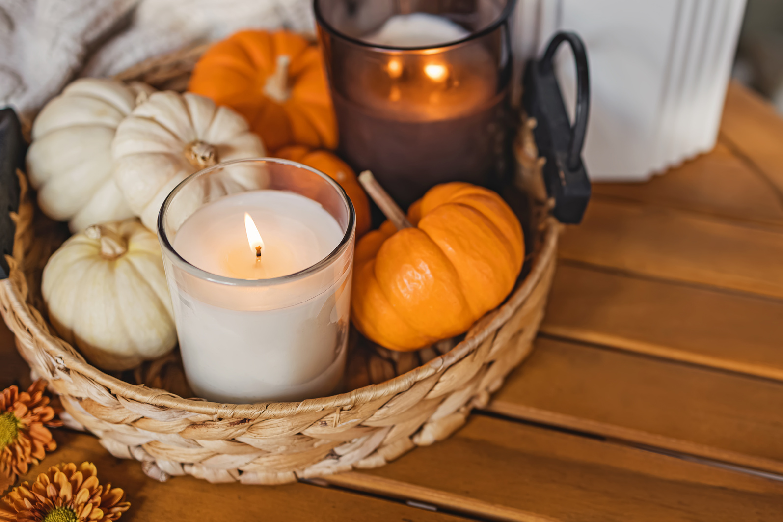 Cozy fall still life composition with decorative pumpkins and burning candle.